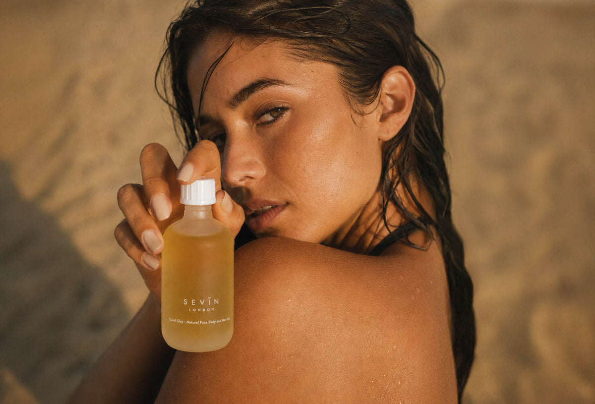 SEVIN model holding face, body hair oil