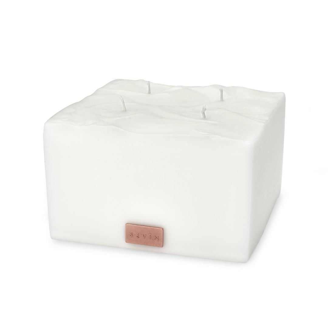 White wedge-shaped cushion with a brand logo on a white background - Porcelain White Scented Candle