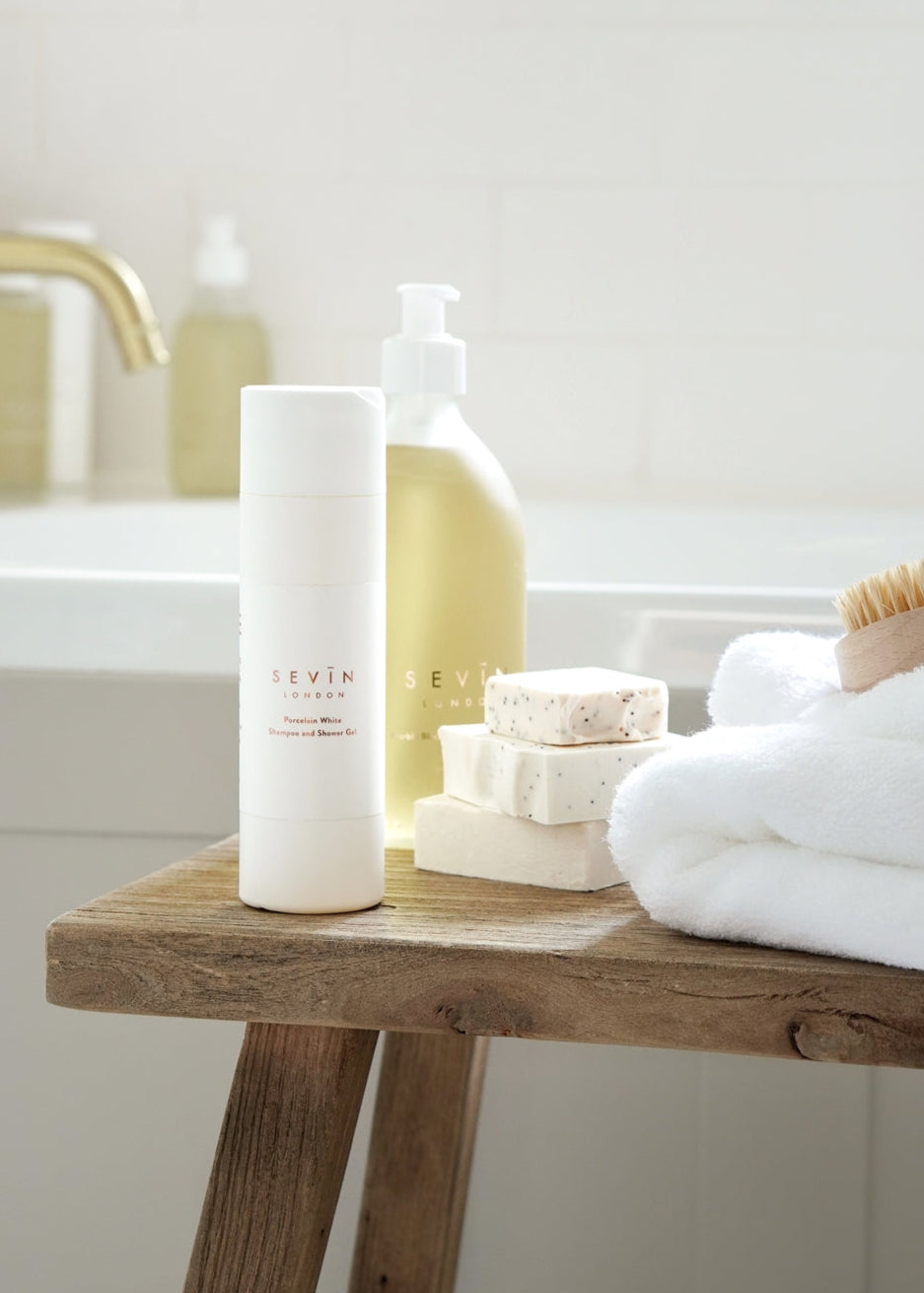 Bathroom setting with SEVIN London products on a wooden stool.